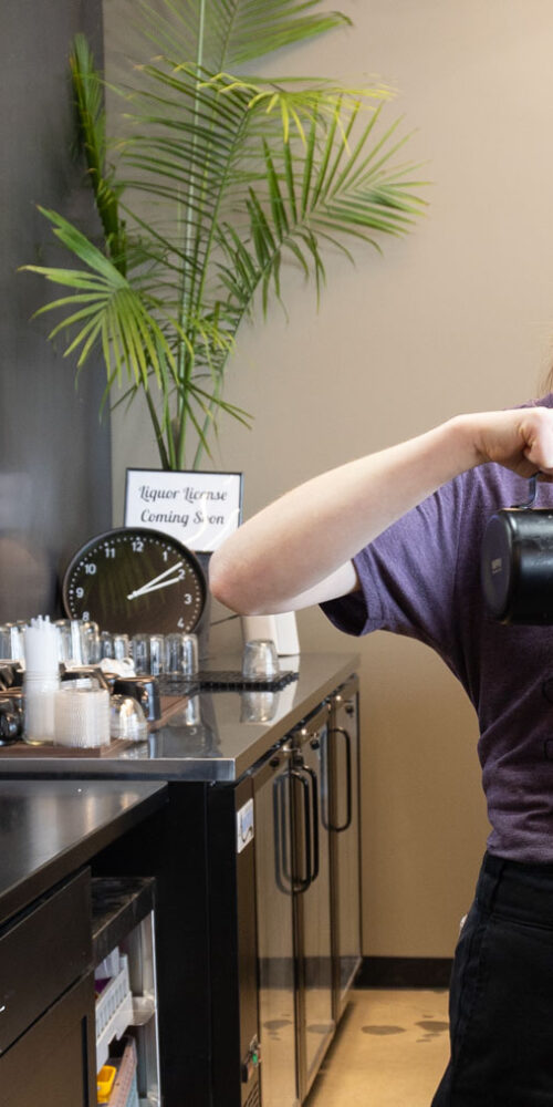 Unique coffee drinks in SLC: A barista pours steamed milk into a latte at Cupla coffee shop in Salt Lake City.