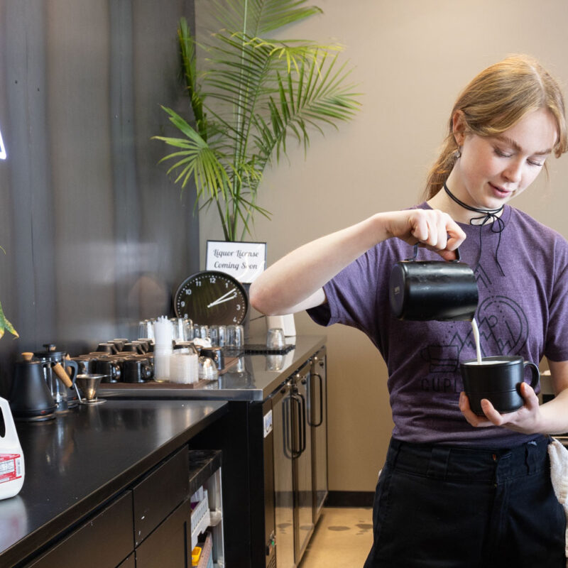 Unique coffee drinks in SLC: A barista pours steamed milk into a latte at Cupla coffee shop in Salt Lake City.