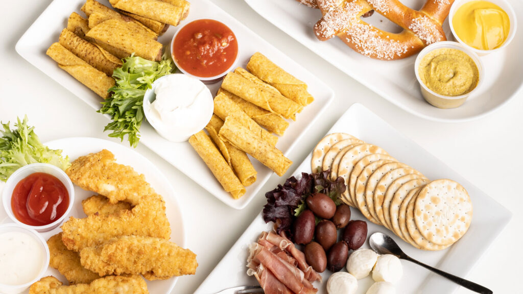 Assorted café food including pretzels, chicken tenders, crackers, and dips served at a local eatery in Park City.